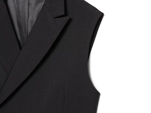 Detail shot of the notched lapel and twill fabric texture on a black sleeveless vest