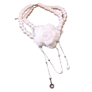 Elegant double-layered pearl necklace with a white knit flower and silver metal tassels
