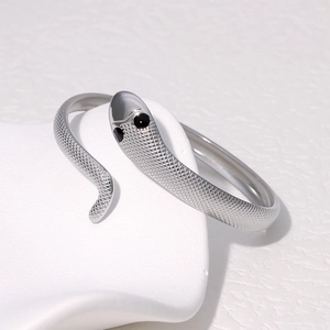Detailed close-up of a silver snake bangle with scale texture and black crystal eyes