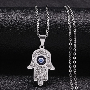 Detailed close-up of Hamsa hand pendant with blue evil eye and sparkling rhinestones