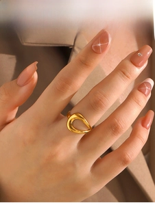 Close-up of a hollow teardrop-shaped gold ring worn on a finger for a chic urban look