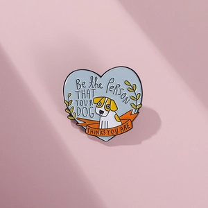 Detail of blue heart enamel pin with cartoon dog and inspirational quote illustration
