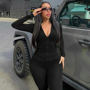 Women's black zipper workout set with slim-fit jacket and leggings in outdoor city setting