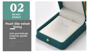 Macro detail of dark green jewelry box showing soft white beaded velvet lining and gold clasp