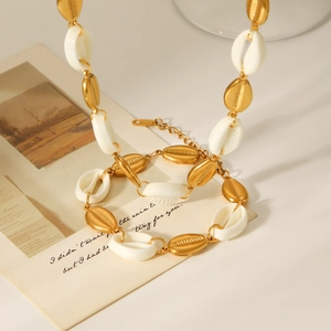 Detail view of alternating white natural shells and golden metal shells on a stylish necklace