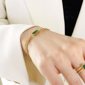 Golden double chain bracelet with green emerald gemstone and matching ring on model