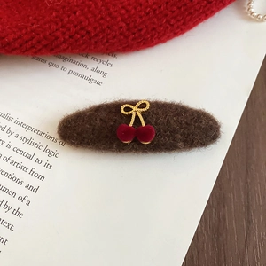Detail of plush brown cherry hairpin with red velvet balls on vintage magazine background