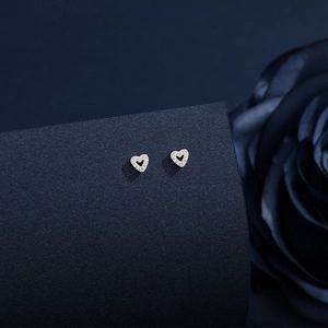 Close-up of heart-shaped S999 sterling silver stud earrings with sparkling cubic zirconia