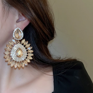 Detail view of champagne teardrop crystal earrings on model with sparkling floral design