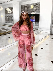 Detail of pink floral chiffon off-shoulder crop top and wide-leg trousers with headband