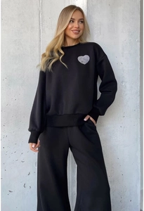 Detail of black tracksuit featuring heart print sweatshirt and wide-leg drawstring pants