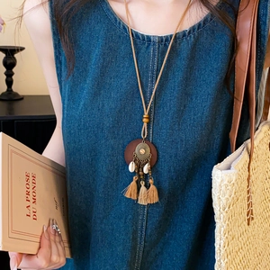 Boho-Halskette mit Holzperlen und langen Fransen getragen zu einem Jeans-Outfit