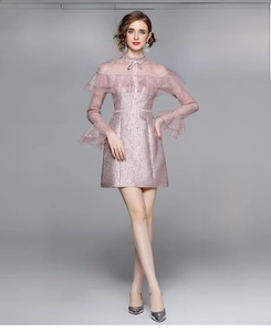 Détail d'une robe en dentelle rose pâle avec broderie et nœud papillon au décolleté