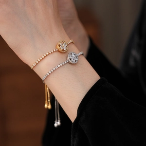 Close-up of gold and silver rotating clover bracelets with sparkling cubic zirconia