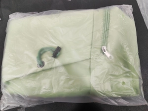 Detail of light green yoga bag showing zipper, drawstring, and buckle in packaging