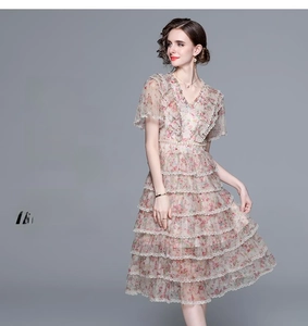 Détail d'une robe fleurie en mesh avec col en V, jupe à volants et manches à froufrous