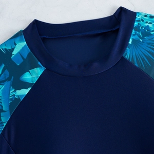 Détail du col rond et manches raglan avec imprimé tropical sur un maillot sport