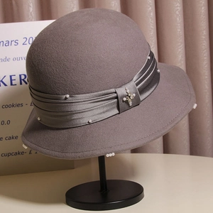 Detailed view of dark grey wool felt hat with satin ribbon, pearls, and rhinestone embellishments