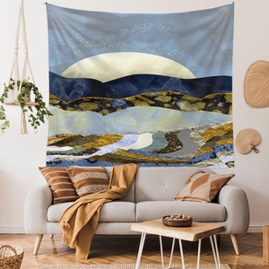 Close-up of abstract mountain tapestry with sun and landscape art hanging over a sofa