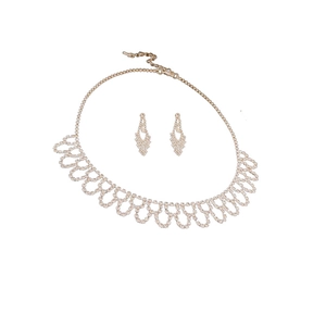 Elegante set di collana con frange dorate e orecchini con strass su sfondo bianco puro