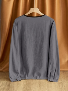 Detail shot of a dark grey linen Henley shirt featuring a buttoned cuff on the sleeve