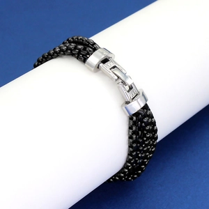 Detail of multi-layered black bead chain bracelet with silver metal clasp on white prop