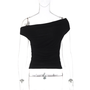 Dettaglio del top nero monospalla aderente con eleganti pieghe orizzontali texture