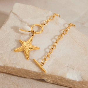 Golden stainless steel bracelet with starfish and shell charms on beige stone
