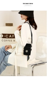 Close-up of black nylon crossbody mobile phone bag with adjustable strap and front pocket