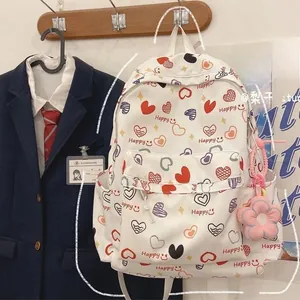 Detailed view of white canvas backpack featuring heart patterns and sunflower pendant