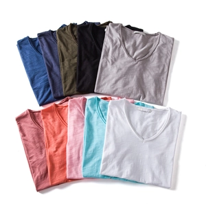 Flat lay of multiple colored V-neck cotton T-shirts showcasing slub cotton texture