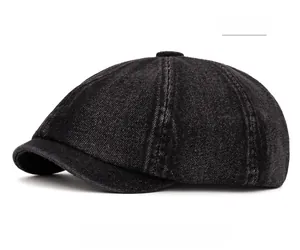 Detailed close-up of a black washed denim newsboy cap with classic stitched crown