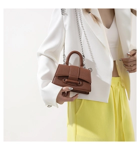 Detailed shot of brown litchi leather mini handbag with stylish beaded chain strap