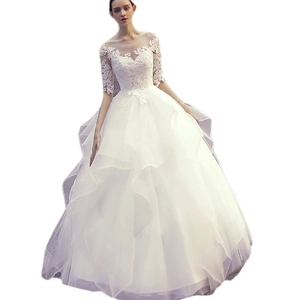 Elegant white lace ball gown wedding dress with long sleeves and layered tulle skirt