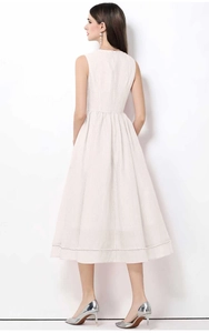 Détail de la robe blanche sans manches avec relief gaufré et taille haute élégante