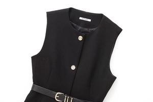 Détail de la robe gilet noire sans manches avec boutons dorés et ceinture à la taille