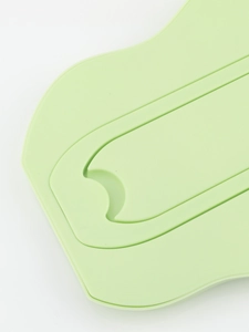 Macro detail of cloud-shaped mirror showing soft green matte finish and curved edges