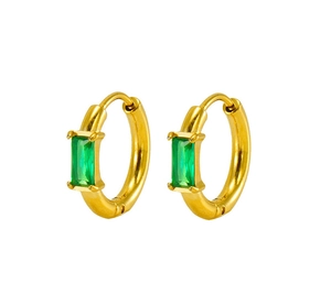 Detailed macro view of gold huggie hoop earrings featuring rectangular emerald cut green stones