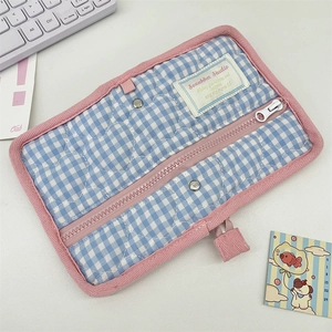 Detailed close-up of blue gingham quilted binder cover with pink trim and zipper closure