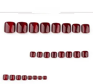 Detailed view of dark red cat-eye press-on toenails in various sizes on white background