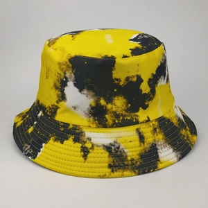 Detail of yellow and black tie-dye pattern on cotton bucket hat with fine fabric texture