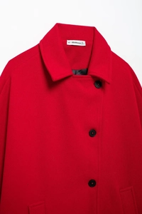 Close-up of red wool coat lapel with black buttons and detailed fabric texture