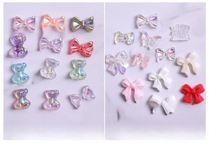 Macro detail of assorted 3D resin nail charms with butterfly, bear and bow motifs