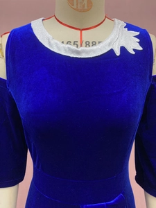 Detail showing white floral embroidery on blue velvet dress with cold shoulder cutouts