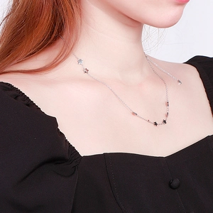 Close-up of a silver star choker necklace on neck showing minimalist pendant details