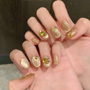 Handmade orange cat-eye press-on nails with colorful dots and 3D star charms