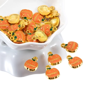 Macro detail of pumpkin charms with orange enamel and gold finish for jewelry making