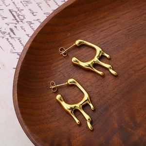 Golden lava texture geometric earrings in stainless steel on a vintage wooden tray