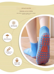 Detail of baby anti-slip socks with orange grip dots on light blue breathable cotton fabric
