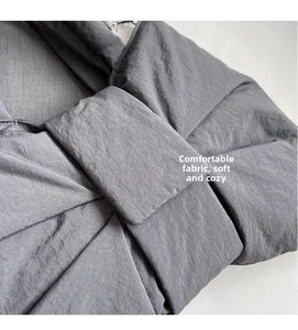 Detail of grey padded nylon fabric texture with soft quilted folds on a shoulder bag